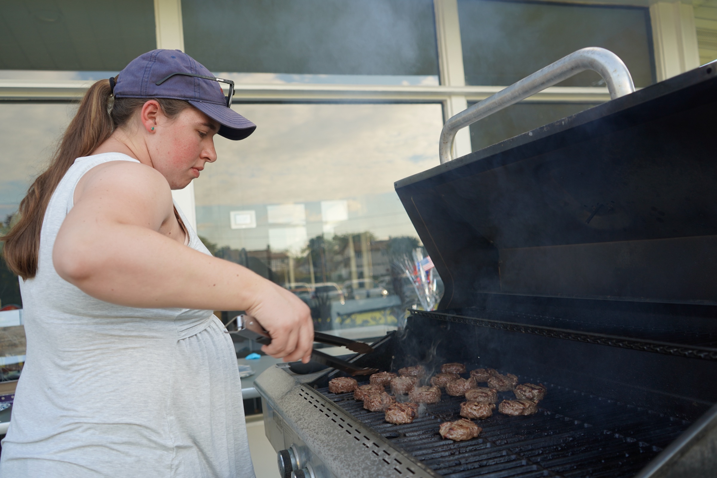 Young woman grilling burgers at a CFC cookout