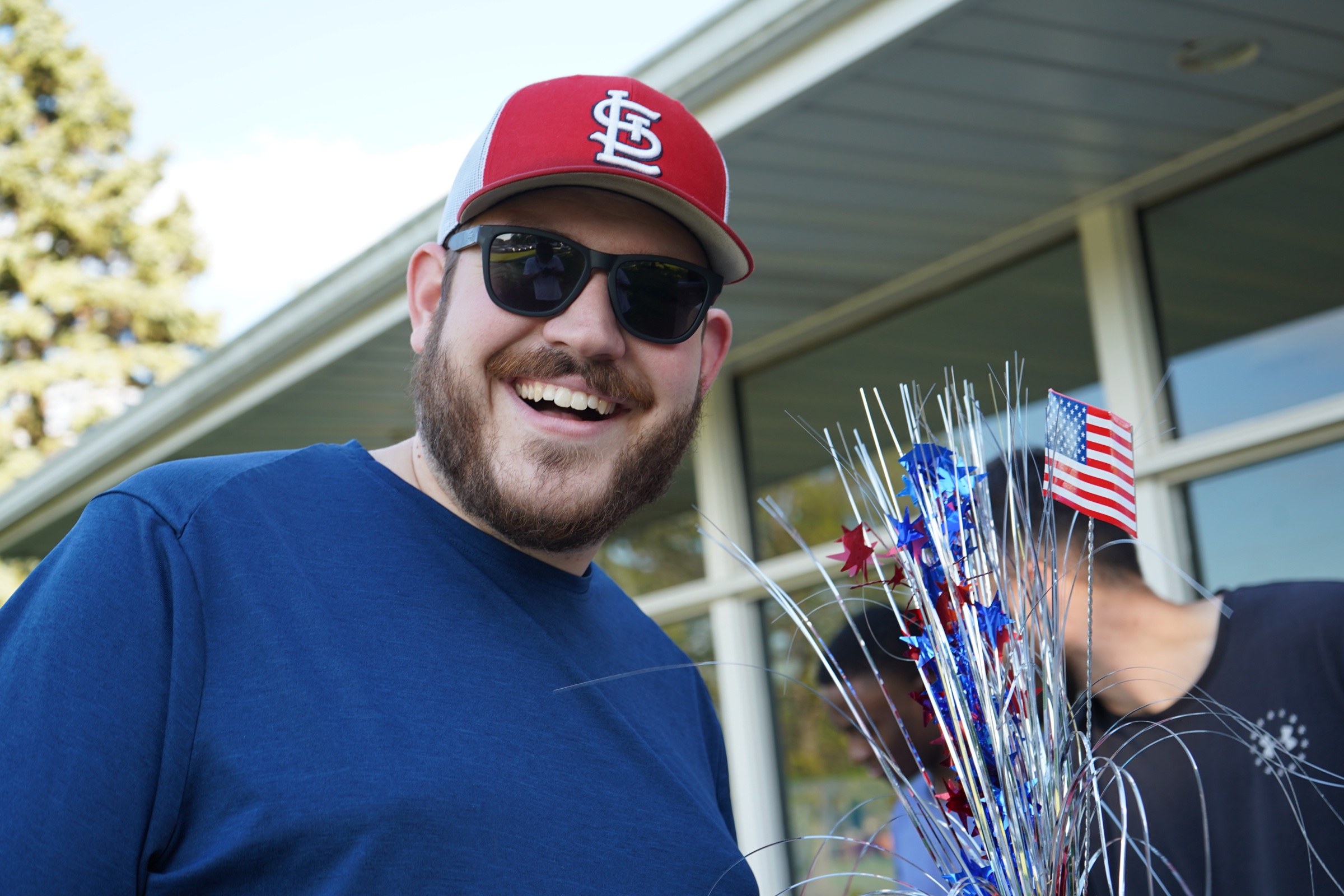 Young man in Cardinals cap holding party decorations