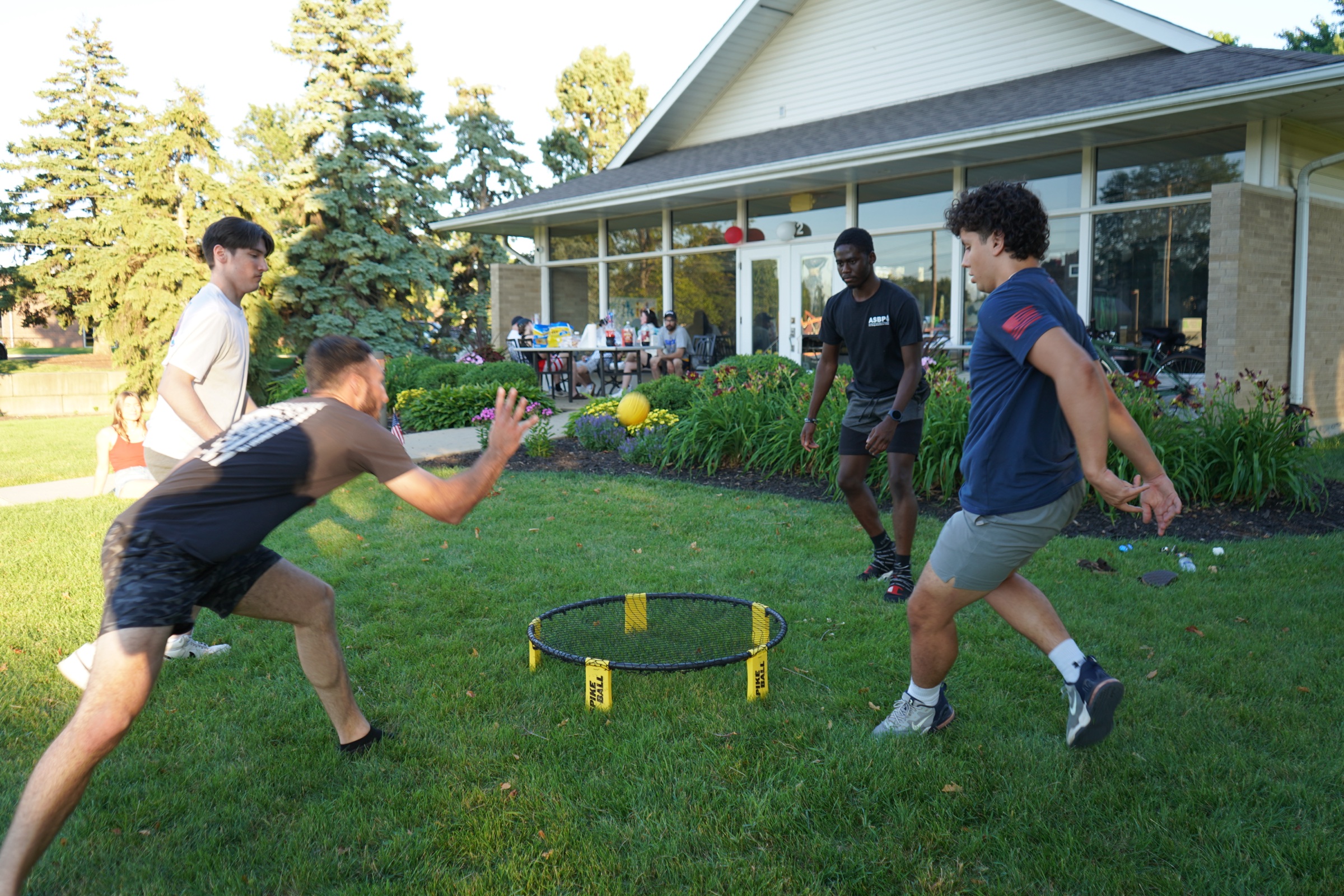 Spikeball game on the lawn during Young Adults night