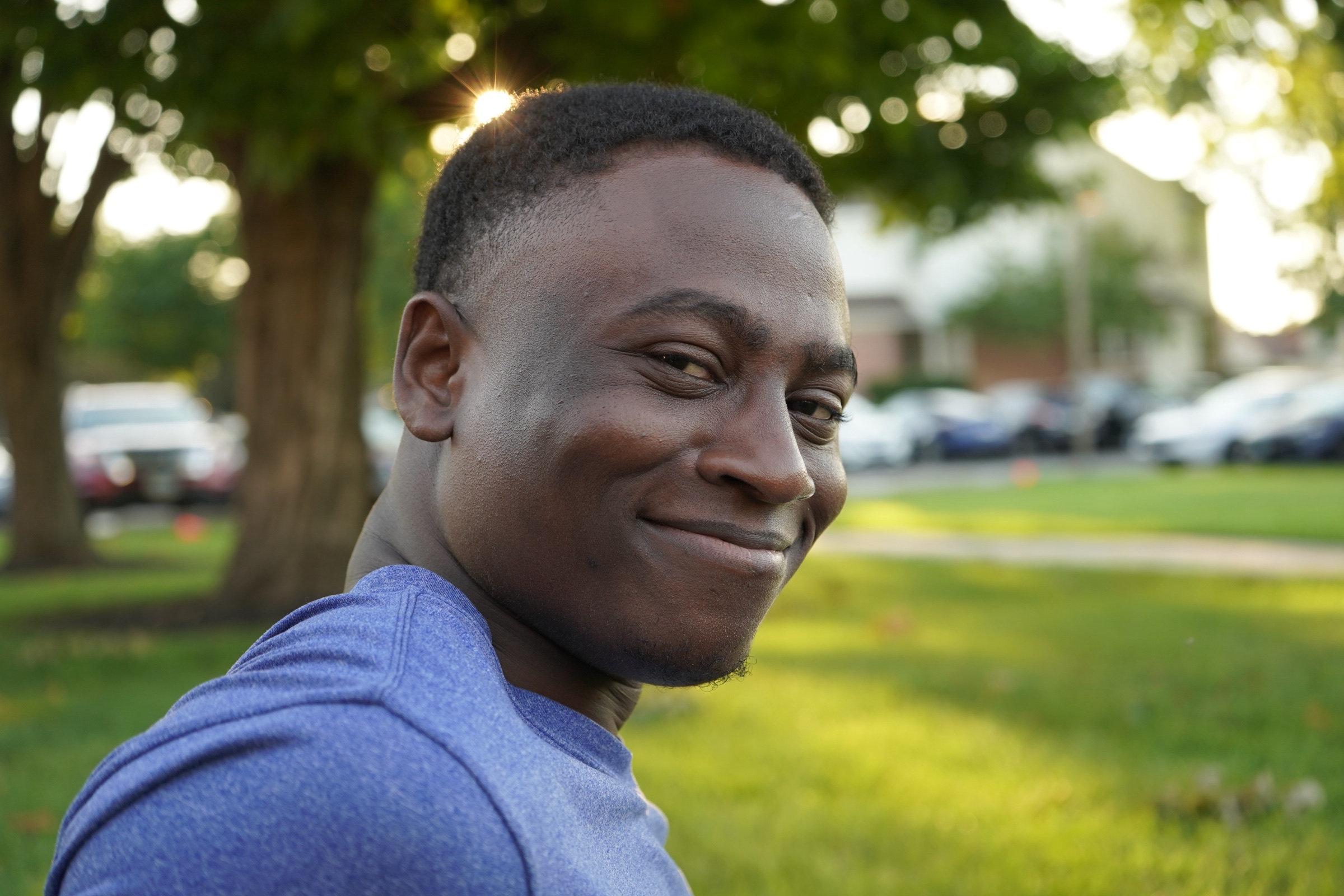 Young man looking over his shoulder with sun flare