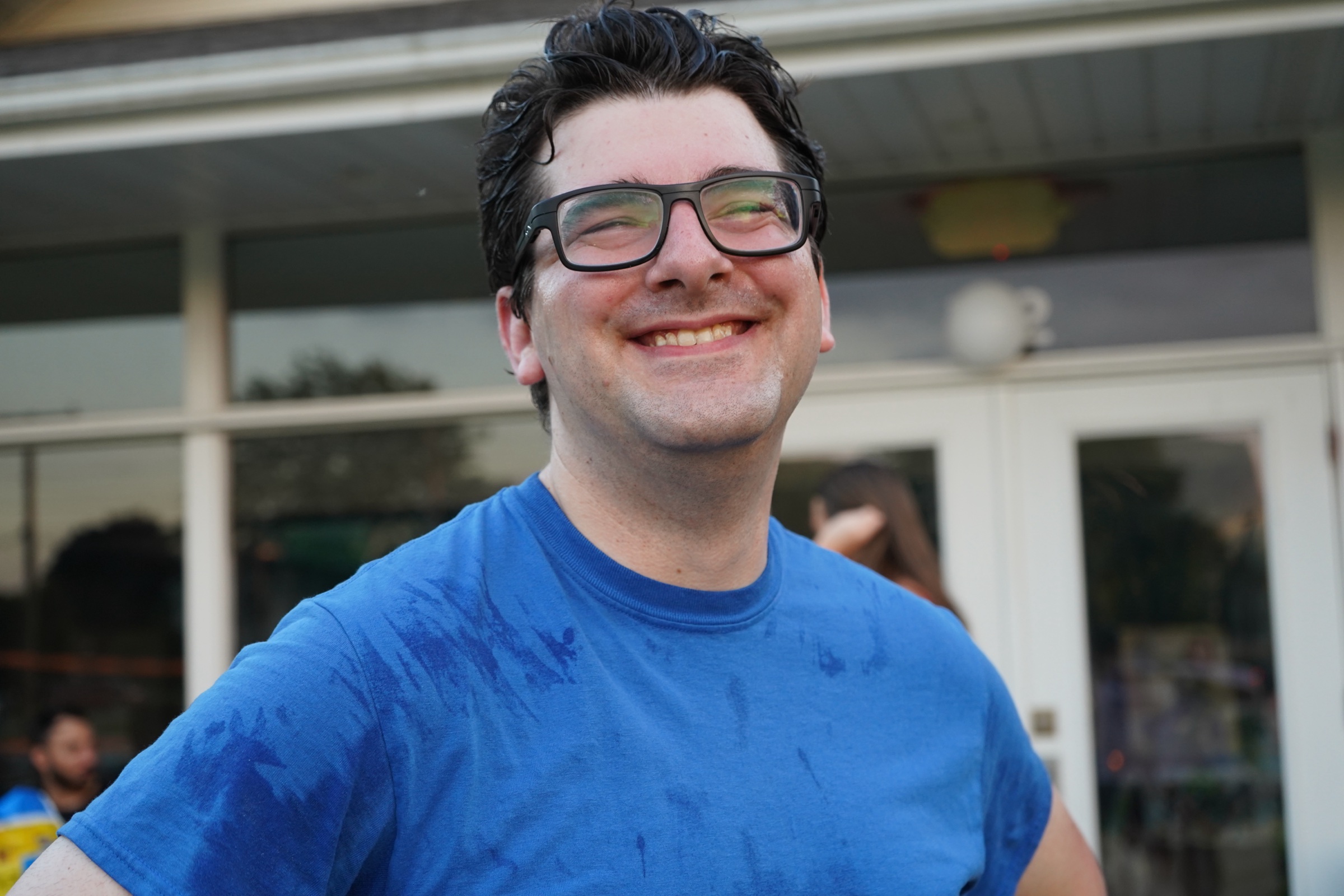 Young man in blue shirt standing near building doors